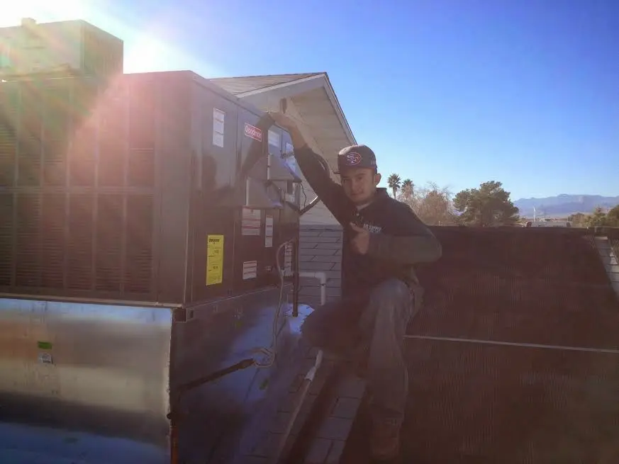 HVAC technician performing Air Duct Cleaning on a rooftop unit in Rio Grande City